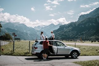three people on a car in a pretty location