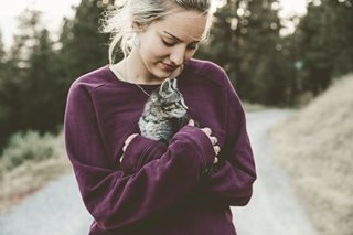 woman holding a small cat outside