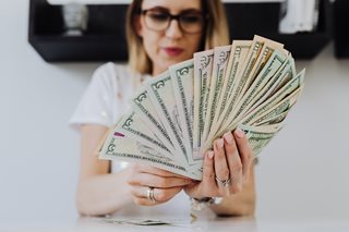 woman holding a stack of cash