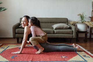 woman doing yoga with her daughter