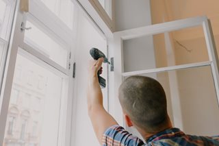 man screwdriving a door hinge