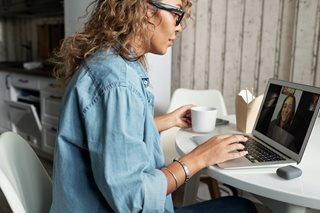 woman sitting at a computer video chatting on