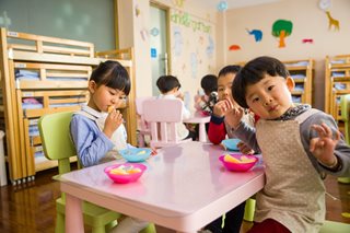 kids eating a snack at a table in a classroom