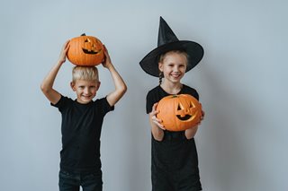 two kids holding jack-o-lanterns