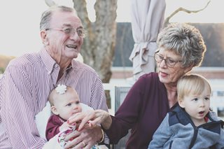old couple holding young children