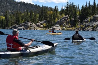 three people kayaking on a river