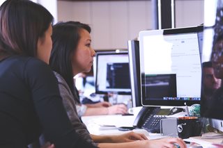 two woman looking at a computer