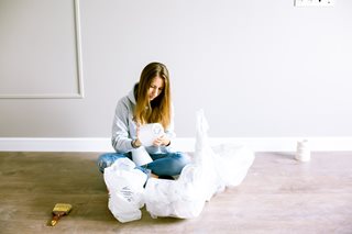 woman sitting on the floor surrounded with supplies