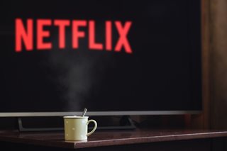 Netflix on a TV with a steaming hot cup of coco