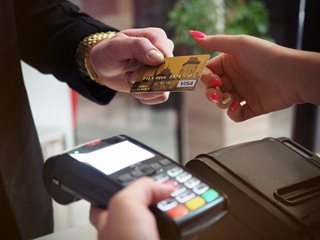 man handing a credit card to another person