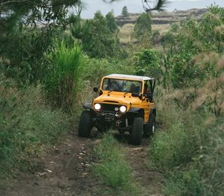 jeep driving up a dirt trail