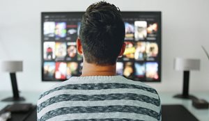 back of a man watching Netflix on a TV