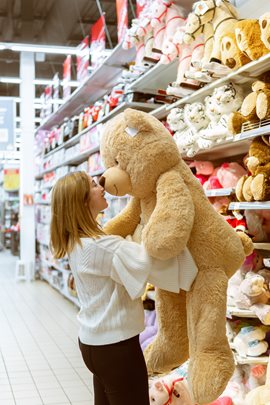 woman holding up a giant teddy bear