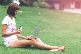woman with card holding a laptop