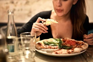 woman eating a slice of pizza