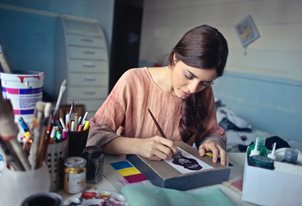 woman painting a small picture