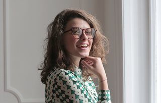 woman smiling at a camera wearing glasses