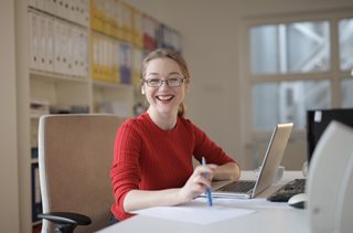 woman sitting at laptop smiling