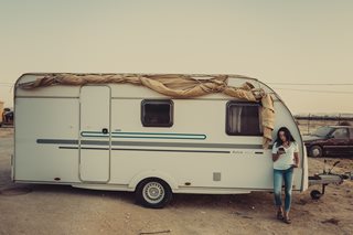 woman leaning against an RV trailer