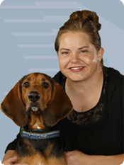 Woman smiling with her cute brown dog next to her