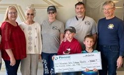 group of people holding a large check