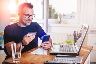 man holding a credit card looking at his phone