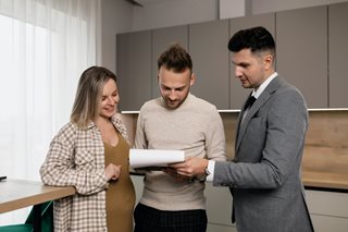 couple buying a house from a man in a suit