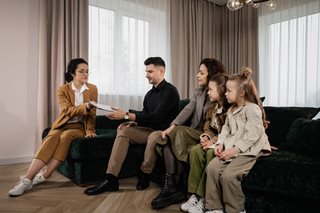 family signing paperwork on a couch