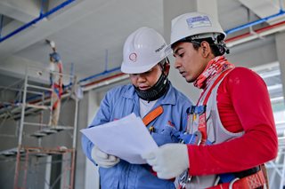 two people with hard hats working