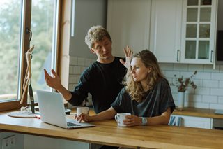 man and woman talking in a kitchen