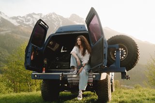 woman sitting in back of van