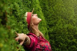 happy woman with bush behind her