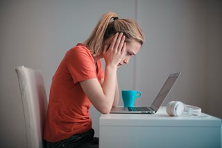 young blonde woman starring intently at a laptop