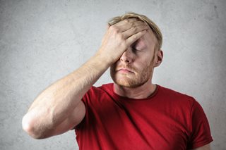 man slapping his own face is frustration