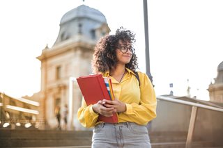 woman walking holding books