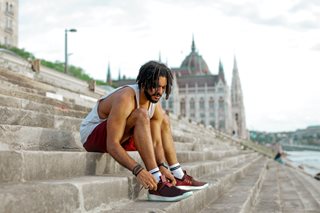 black man tying sneakers on stairs