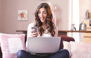 woman excited looking at smartphone