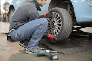 person replacing a tire