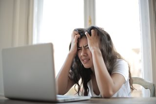 young woman frustrated looking at computer