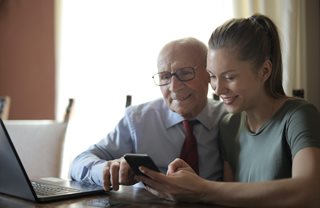 old grandpa and young woman looking at smartphone