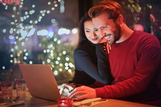 man and woman shopping on laptop