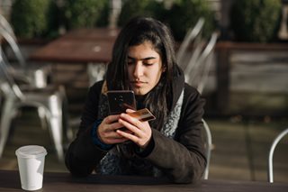 woman holding a phone and credit card