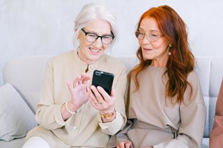 two old woman looking at a phone