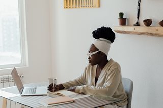 black woman with paper and laptop