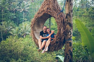 man and woman sitting in tree seat