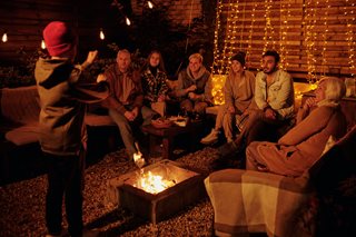 group of friends around a pit fire