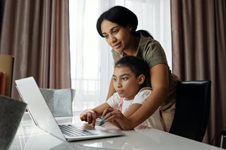 mother helping child with a laptop