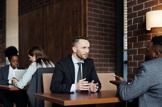 two men talking in suits