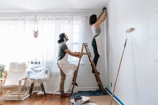 man and woman painting a room