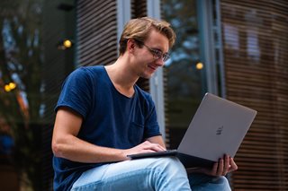 man with glasses looking at laptop
